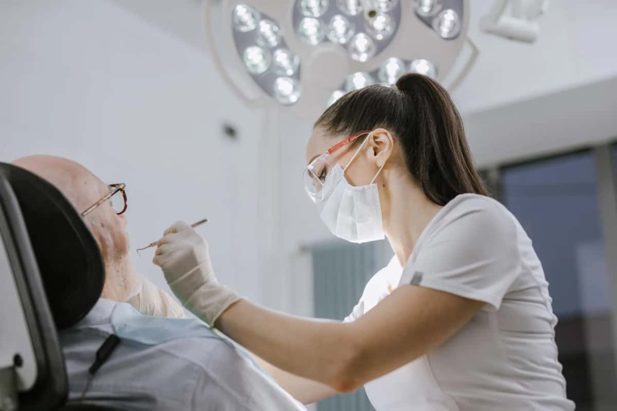 Praticienne soignant un patient dans un cabinet dentaire