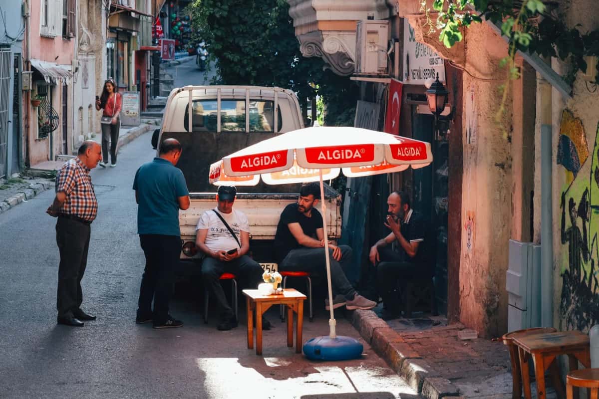 Voisins attablés autour d'un thé dans une rue de quartier à Istanbul